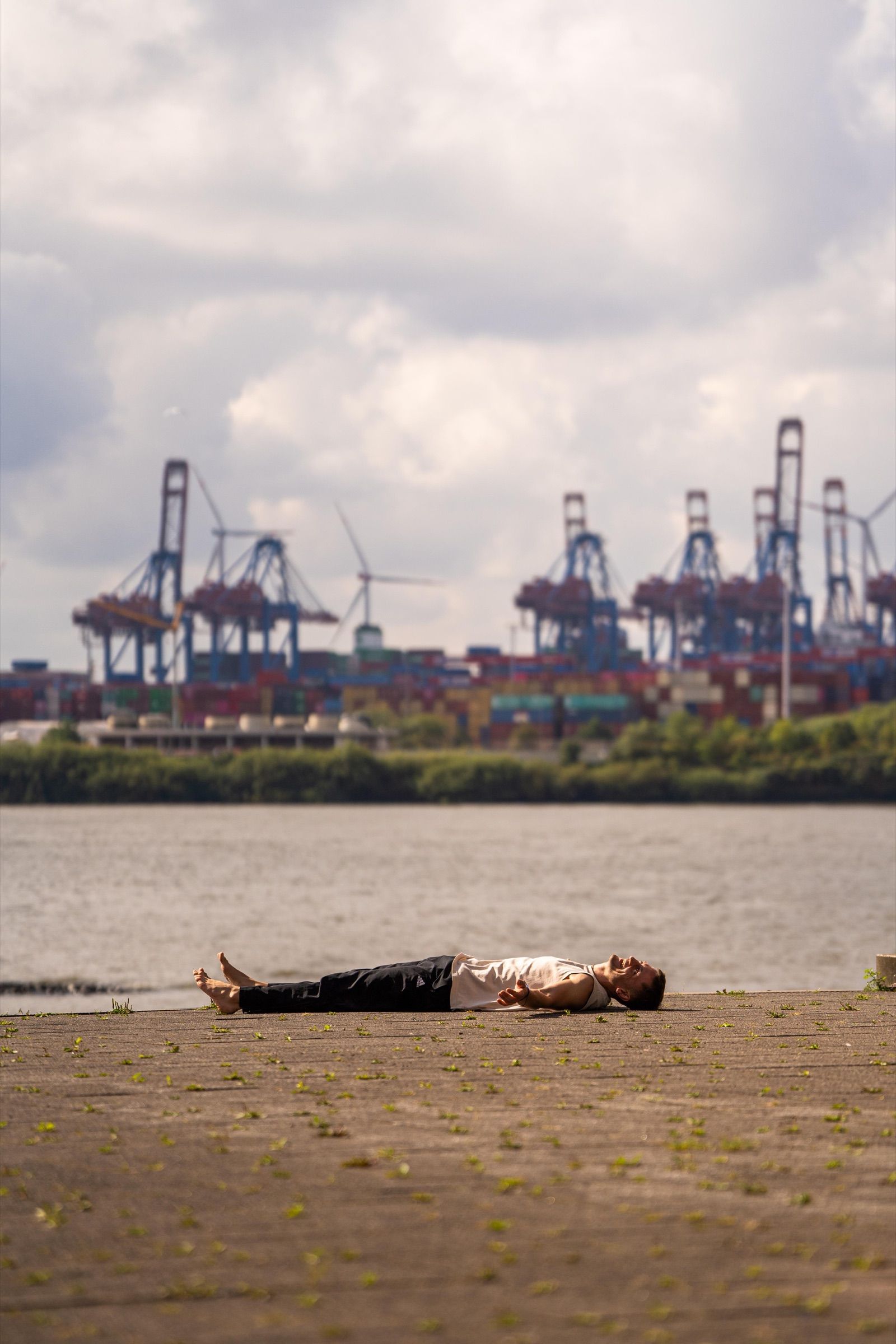 Lennart lying in savasana beside the Hamburg harbour